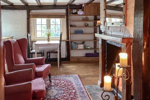 Guest lounge with arm chairs log burner and table and chairs