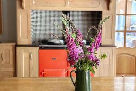 Table with wildflower arrangement and aga in background