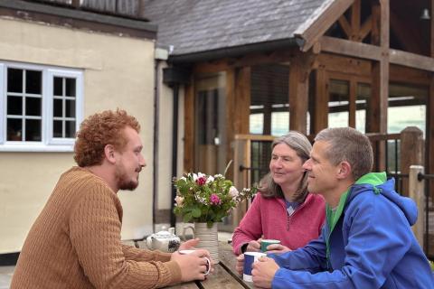 Three people around picnic table