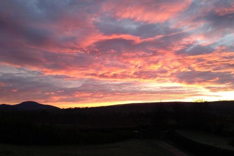 Red clouds over dark landscape
