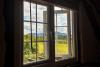 Open bedroom window with view over fields and hills in the distance