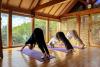 Three people practicing yoga in sunny room
