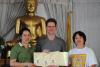 Certificate presentation in front of Thai Buddha